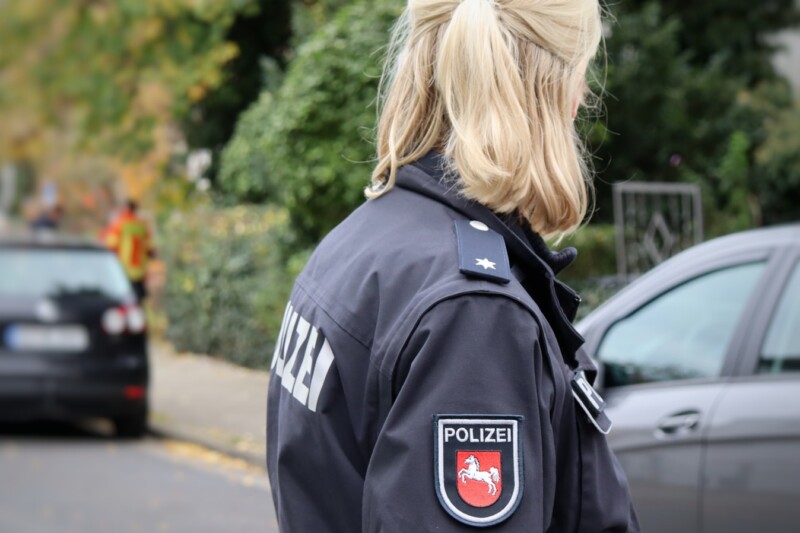 a woman in a police uniform standing on the side of the road