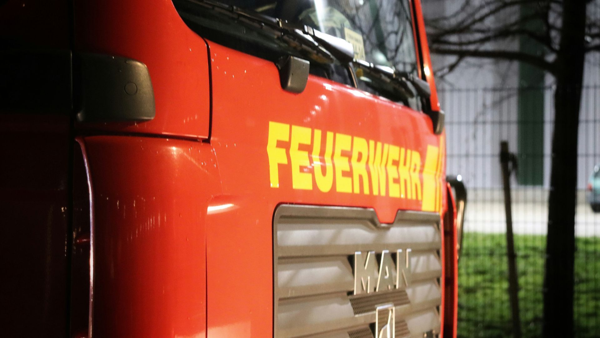 Nahaufnahme eines Feuerwehrfahrzeugs mit dem Schriftzug Feuerwehr in leuchtendem Gelb auf rotem Hintergrund.