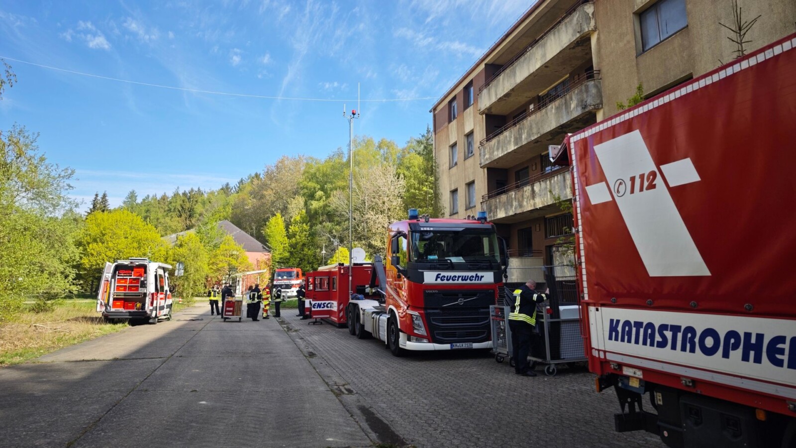 Einsatzfahrzeuge der Feuerwehr und Katastrophenschutz in einer urbanen Umgebung während eines Einsatzes.