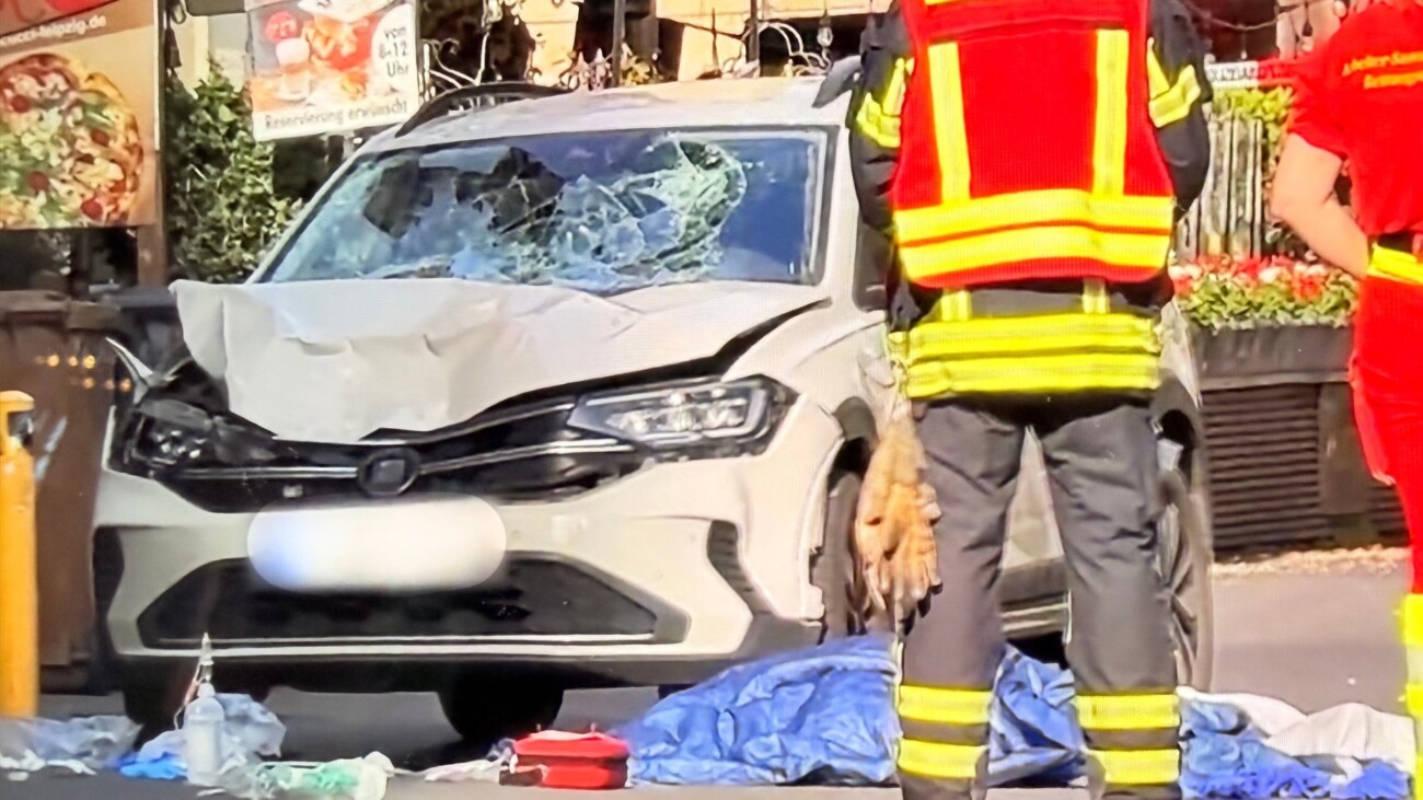 Auto fährt in Leipzig in Menschenmenge