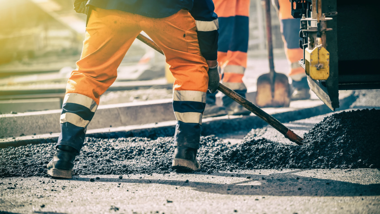 Straßenbaustelle, bei der Asphalt aufgeschüttet wird